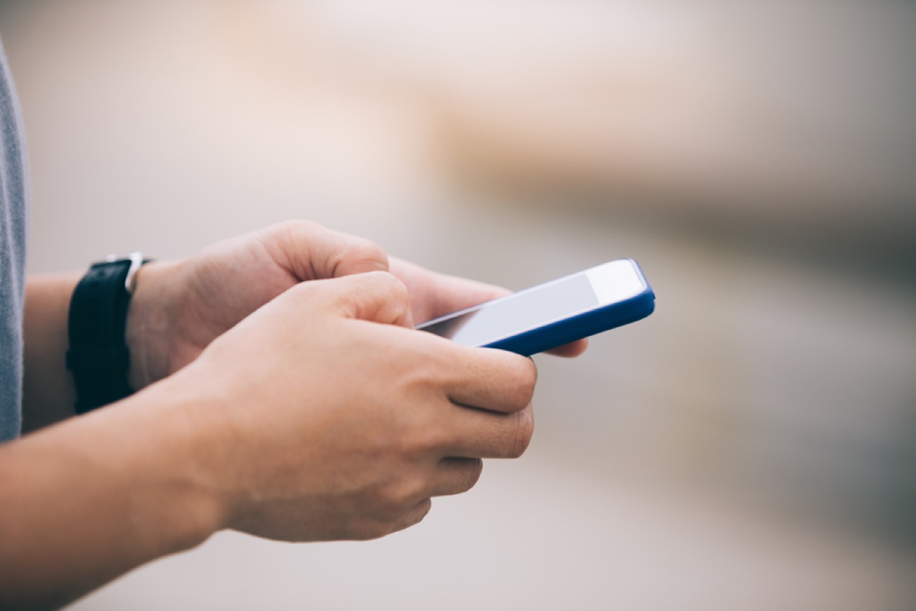 Hands using smartphone outdoor
